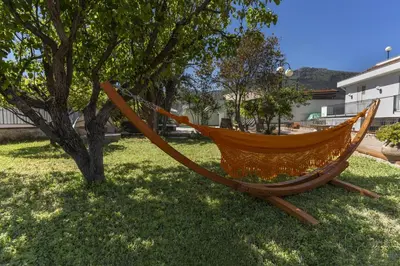 an orange hammock sitting next to a tree at Villa Sandoval in Palermo