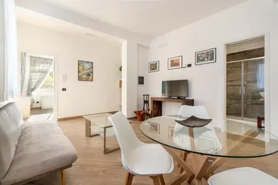 a living room with a glass table and white chairs at Villa Sandoval in Palermo