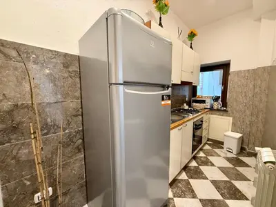 a stainless steel refrigerator in a kitchen with a checkered floor at La Rosa Bianca della Vucciria in Palermo