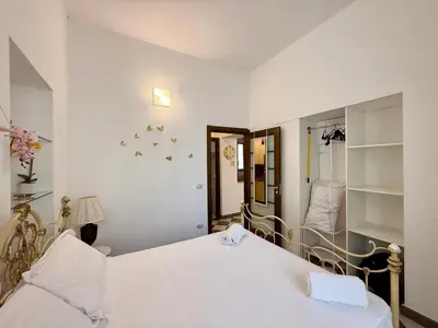 a bedroom with a white bed and a mirror at La Rosa Bianca della Vucciria in Palermo
