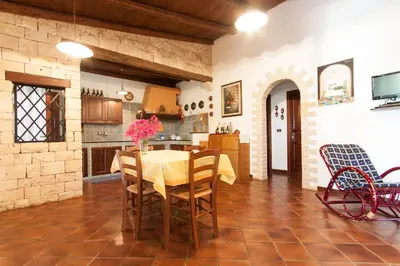 a kitchen and dining room with a table and chairs at Villino Dei Gabbiani in Castellammare del Golfo