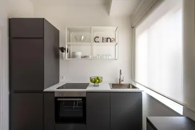 a small kitchen with a sink and a refrigerator at Ruggero City View apartment by Wonderful Italy in Palermo