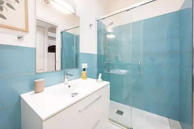 a bathroom with a sink and a glass shower at La Casa di Freda in Palermo