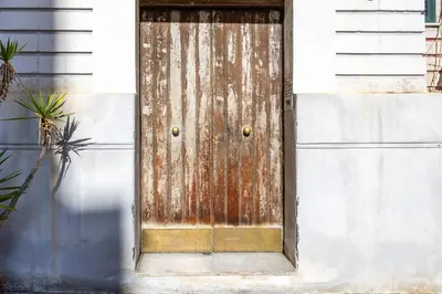 an old rusty door on the side of a building at Casa D'Ondes in Palermo