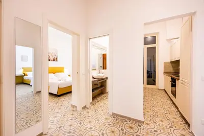 a room with a living room with a bed and a mirror at Casa D'Ondes in Palermo