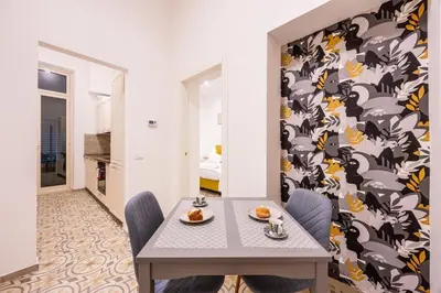a dining room with a table and a patterned wall at Casa D'Ondes in Palermo