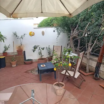 a patio with a table and chairs and an umbrella at Mondello bed & beach in Palermo
