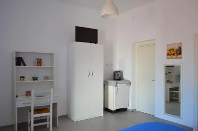 a white room with a desk and a white cabinet at Mondello bed & beach in Palermo