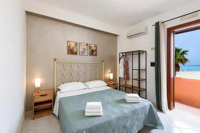 a bedroom with a bed with a view of the beach at Beach View Apartment in San Vito lo Capo