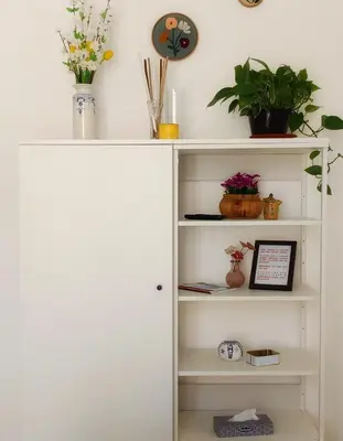 a white book shelf with flowers and plants on it at Capo Petit Apartment in Palermo
