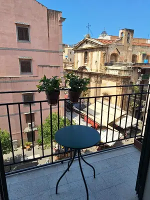 a table on a balcony with a view of a city at Capo Petit Apartment in Palermo