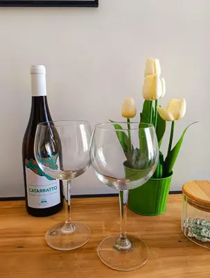 two wine glasses sitting next to a bottle of wine at Capo Petit Apartment in Palermo