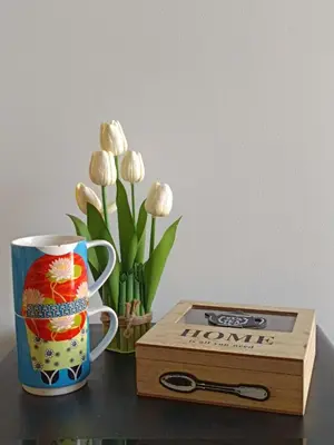 a table with a mug and a box and flowers at Capo Petit Apartment in Palermo