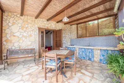 a patio with a table and chairs and a bench at Monolocale Casa Maria in San Vito lo Capo
