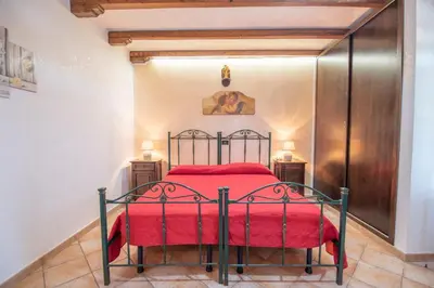 a bedroom with a bed with a red bedspread at Monolocale Casa Maria in San Vito lo Capo