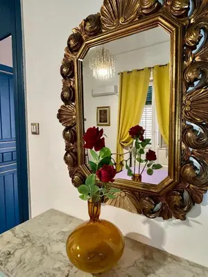 a vase with flowers in front of a mirror at Leon in Palermo