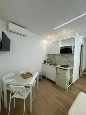 a kitchen with white cabinets and a table and chairs at Glamour home in Palermo
