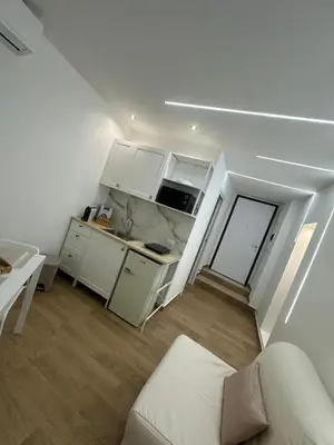 a small kitchen with white cabinets and a table at Glamour home in Palermo