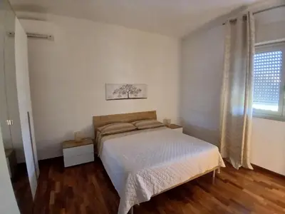 a white bedroom with a bed and a window at Maison Du Parc in Palermo