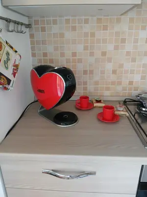 a kitchen counter with a red and black appliance on it at Maison Du Parc in Palermo