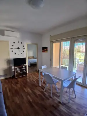 a living room with a table and chairs and a tv at Maison Du Parc in Palermo