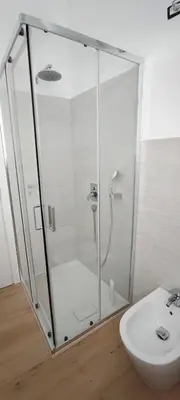 a shower with a glass door next to a sink at Casa Viola - Central Apartment City & Sea in Alcamo
