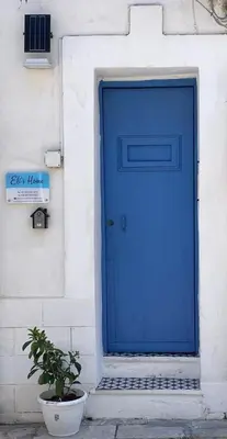 a blue door on a white building with a potted plant at Eli's Home in Terrasini