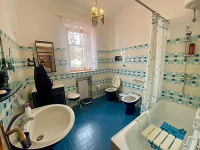a bathroom with two toilets and a sink and a tub at Villa Melina in Carini