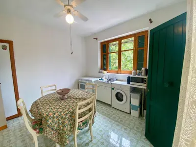 a kitchen with a table and a green door at Villa Melina in Carini