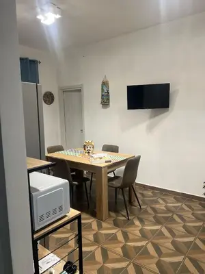 a dining room with a table with chairs and a microwave at Trinacria in Capaci