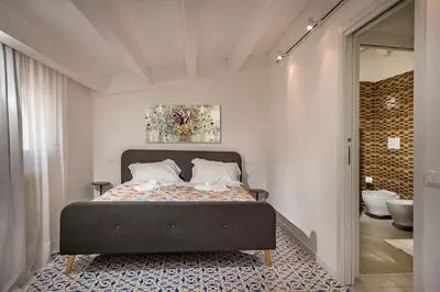 a bedroom with a bed and a bathroom at Terrazza BluOltremare, Castellammare del Golfo in Castellammare del Golfo