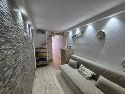 a living room with a couch and a stone wall at Ad 1 passo dal mare Mondello in Palermo