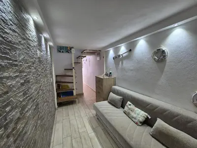 a living room with a couch and a stone wall at Ad 1 passo dal mare Mondello in Palermo