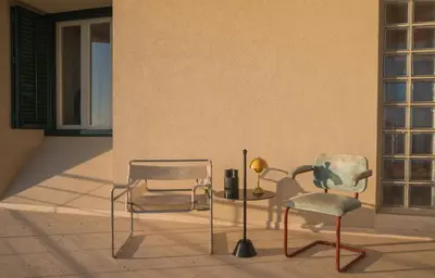 two chairs and a table with a lamp on a patio at Seaside Villa Capo Zafferano in Bagheria