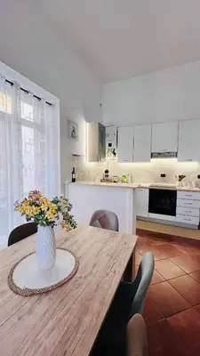 a kitchen with a wooden table with a vase of flowers at Kasa Magnisi in Palermo