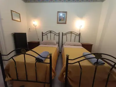 two twin beds in a room with two lights at Casa Mille in Palermo