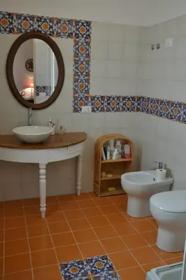 a bathroom with a sink and a toilet and a mirror at B&B Talìa in Scopello