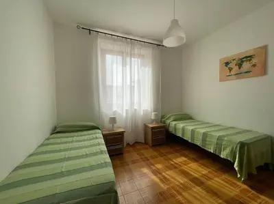 two green beds in a room with a window at I Cinque Archi Apartment in Alcamo