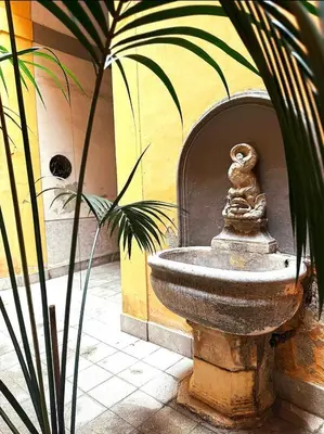 a statue of a squirrel sitting on top of a fountain at Luxury Apartment Palazzo Vannucci in Palermo