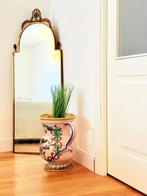 a vase sitting on the floor next to a mirror at Luxury Apartment Palazzo Vannucci in Palermo