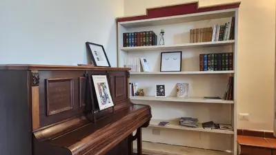 a book shelf filled with books and a piano at Note di Palermo Loft in Palermo