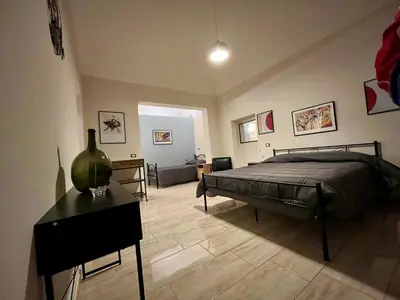 a bedroom with a bed and a table with a vase on it at Donna Maria in Cinisi
