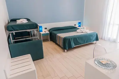 a small room with two beds and a table at Accussì rooms in San Vito lo Capo