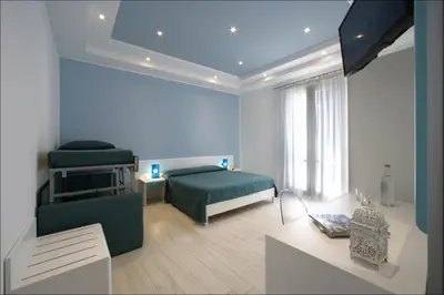 a bedroom with a bed and a couch and a table at Accussì rooms in San Vito lo Capo
