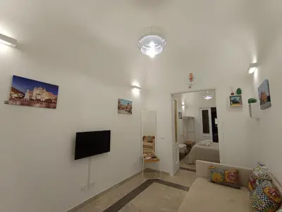a living room with a couch and a tv on a wall at Le meraviglie di Palermo Casa Vacanze Holiday House in Palermo
