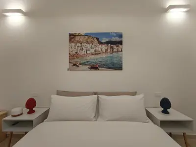 a bedroom with a bed and a painting on the wall at Le meraviglie di Palermo Casa Vacanze Holiday House in Palermo