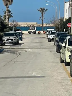 a parking lot with cars parked on the side of the road at nanzi u mare in San Vito lo Capo