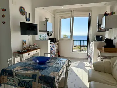 a living room with a table and a view of the ocean at Sea Pearl House in Isola delle Femmine