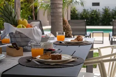 a table with plates of food and orange juice at Villa Dafni Private Pool & Relax near Cefalù in Campofelice di Roccella