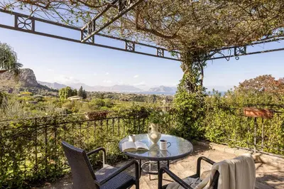 a table and chairs on a patio with a view at Villa Zagara Swimming Pool and Seaview in Ficarazzi